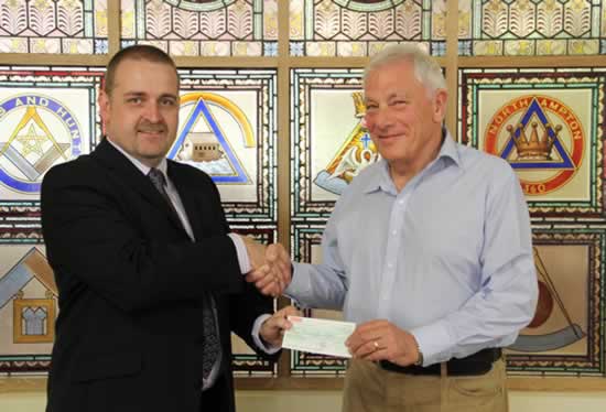  WM, W Bro Craig Davies, presents the cheque to charity trustee, Ian Harvey 